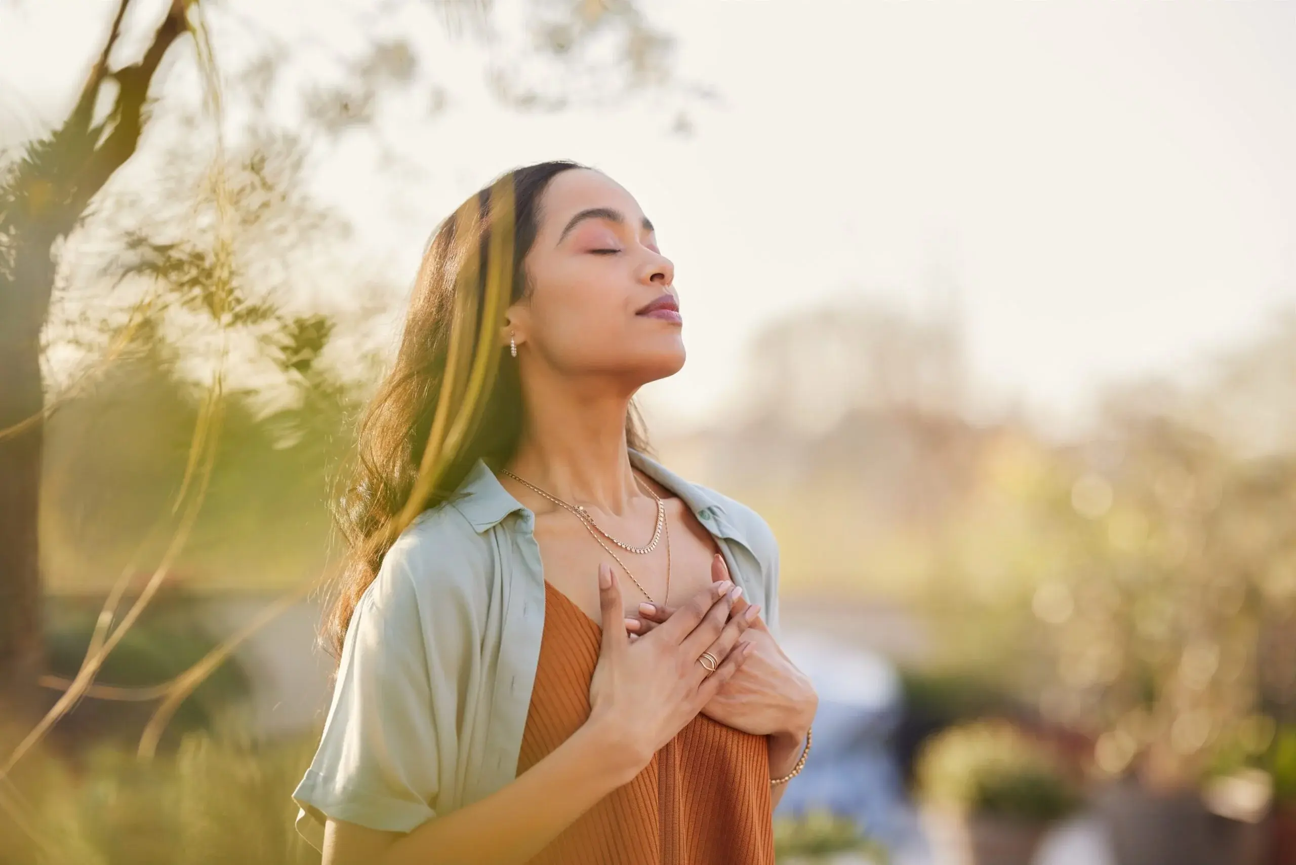 Calm woman with hands over her heart representing healing, resilience, and compassionate psychiatric care at Resilient Psychiatry and Wellness.